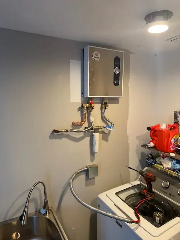 Utility room water heater installation in El Dorado County, CA home, featuring a residential tank-style unit with connected plumbing lines and ventilation system in a clean indoor space.